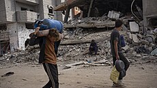 Palestinci procházejí znienými budovami po izraelské letecké a pozemní...