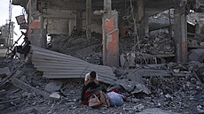 Palestinci procházejí znienými budovami po izraelské letecké a pozemní...