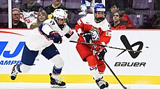 �eská hokejistka Tereza Vani�ová (21) dr�í kotou� p�ed napadající americkou...