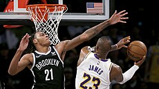 LeBron James (23) z LA Lakers zakonuje na ko Brooklynu, brání ho Noah Clowney...