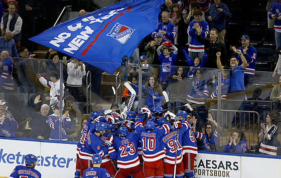 Hokejisté New York Rangers slaví s fanouky.