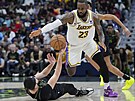 LeBron James (vlevo) z Los Angeles Lakers prochází pes  Larryho Nancea Jr. z...