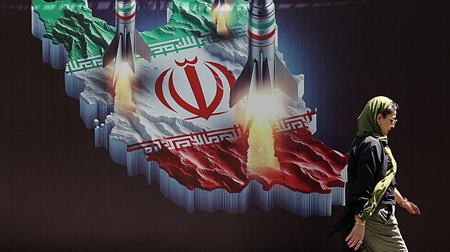 Strach v Teheránu. Íránka prochází kolem protiizraelského transparentu s...