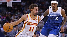 Trae Young z Atlanty postupuje s balonem kolem Jadena McDanielse z Minnesoty.