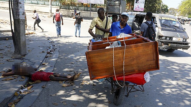 Bný obrázek. V haitské metropoli lidé za denního svtla pekraují tla...