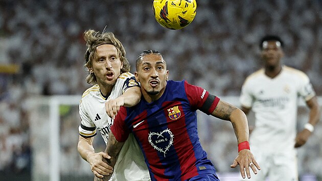 Zlonk Luka Modri z Realu Madrid (vlevo) se sna dostat k mi pes barcelonskho Raphinhu.