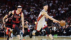 Tyler Herro v zápase o postup do play off, brání ho Alex Caruso.