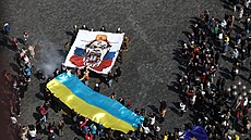 Zhruba stovka Pra�an� a kolemjdoucích turist� v ned�li na Starom�stském nám�stí...