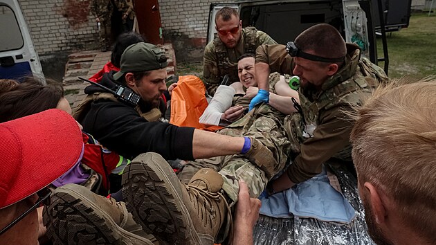 Zdravotnci u msta Vovansk v Charkovsk oblasti oetuj zrannho ukrajinskho vojka. (12. kvtna 2024)