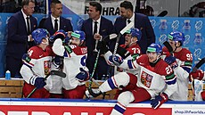 Čeští hokejisté i realizační tým slaví výhru po samostatných nájezdech nad...