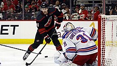 Martin Neas z Caroliny stílí na brankáe NY Rangers Igora esorkina.