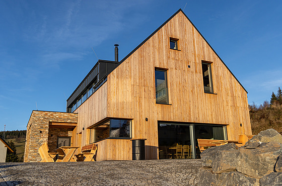 Fasády objektu architekti vy�e�ili d�ev�ným a kamenným obkladem, který ladí s...