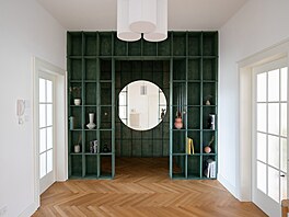 Výrazné zelené zádve�í s kruhovým zrcadlem je bránou do bytu.