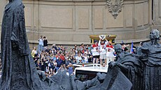 �e�tí hokejisté p�ijí�d�jí na Starom�stské nám�stí, fanou�ky vítají s pohárem...