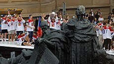 �e�tí hokejisté na Starom�stském nám�stí zdraví ze st�echy autobusu fanou�ky.