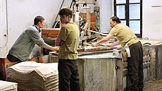 D�lníci v ru�ní papírn� pracují se síty, do kterých se nabírá papírovina.