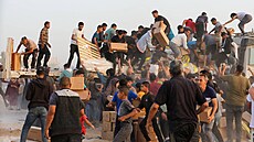 Palestinci berou krabice s humanitární pomocí z nákladních aut p�evá�ejících...