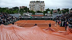 Po�adatelé natahují plachtu p�es kurt, aby ho ochránili p�ed de�t�m. Ten toti�...