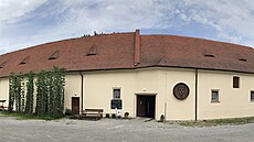 Ped opravenou budovou se nachází ukázková chmelnice.