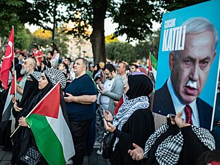 Protestující pod fotografií izraelského premiéra Benjamina Netanjahua s nápisem...