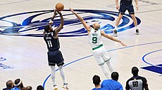 Kyrie Irving z Dallas Mavericks zakonuje pes Derricka Whita z Boston Celtics...