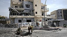 Zkáza. Izraelské síly v Kirjat �mona prozkoumávají místo dopadu rakety...