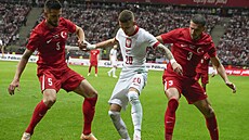 Polský fotbalista Sebastian Szymanski (uprosted) v souboji s Turky Okay...
