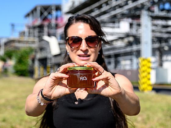Specialistka komunikace Iva Sobotková s medem z produkce v�el na okraji areálu...