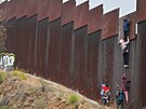 Migranti se snaí dostat pes plot steící hranici Mexika a USA. (7. ervna...