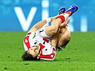 Gruzínský fotbalista Chvia Kvaracchelija padá na trávník.