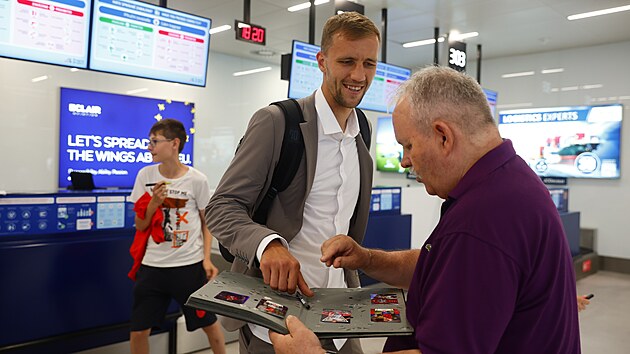 Reprezenta�n� kapit�n Tom� Sou�ek se po n�vratu t�mu do �eska podepisuje na leti�ti fanou�k�m.