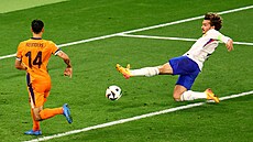 Francouzský úto�ník Antoine Griezmann podkluzuje v �anci v utkání s Nizozemskem.