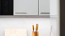 Bílá kuchyská linka splývá se stnami.