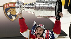 Aleksander Barkov z Floridy se Stanley Cupem nad hlavou.