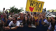 MILUJEME T� POGI. Tadej Poga�ar projí�dí pod transparentem vyznávajícím mu...