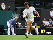 Vít Kopiva se natahuje po míku v prvním kole Wimbledonu.