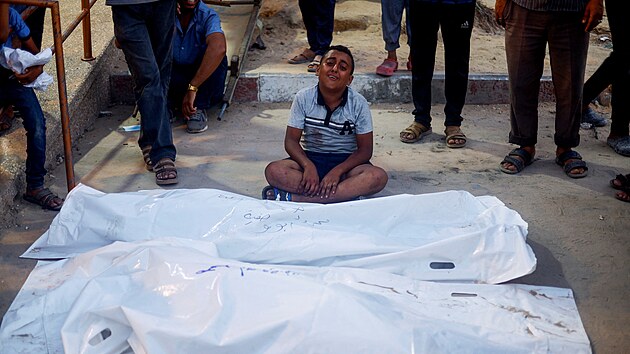 Chlapec pl��e u t�l Palestinc� po izraelsk�m �deru v Ch�n J�nisu na jihu P�sma Gazy. (9. �ervence 2024)