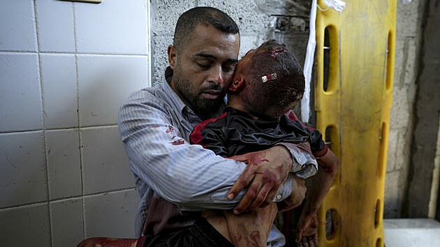 Palestinsk� otec obj�m� t�lo sv�ho syna, kter� zem�el p�i izraelsk�m �toku v Dajr Bal�hu v centr�ln� ��sti P�sma Gazy. (9. �ervence 2024)