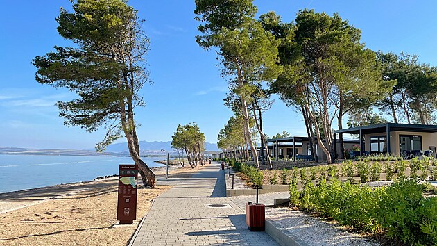 Aminess Avalona Camping Resort. Hlavn� promen�da vede kolem pl�� ostrova Pag. V pozad� je poho�� Velebit.