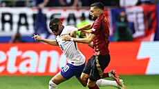 S maskou hrající kapitán Francie Kylian Mbappé se snaí pejít pes Belgiana...