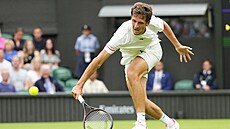 Vít Kopiva dobíhá míek v prvním kole Wimbledonu.
