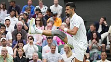 Novak Djokovi se protahuje v prvním kole Wimbledonu.