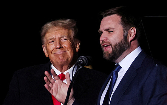 Vance mluví, zatímco bývalý prezident USA Donald Trump se usmívá na shromádní...