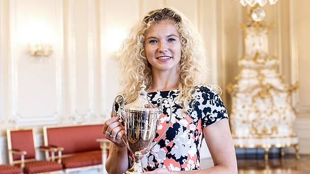 Tenistka Kateina Siniakov pzuje s trofej za wimbledonsk vtzstv ve tyhe. (18. ervence 2024)
