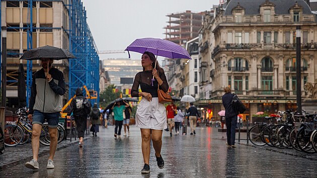 Lid� proch�zej� po ulici v Bruselu b�hem siln�ch de���. (9. �ervence 2024)