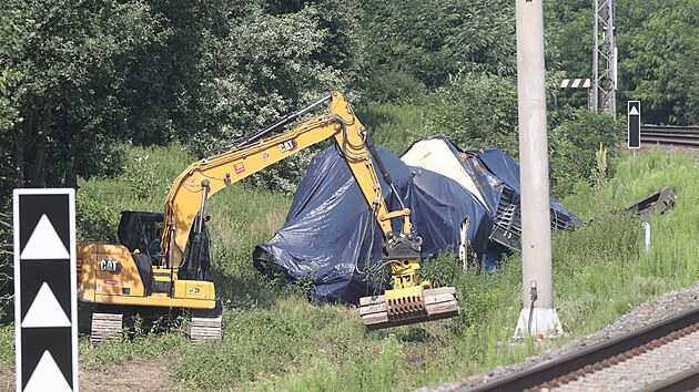 Stavebn stroje nyn pokldaj mezi silnici  a ponienou lokomotivu u trati panely, aby byl pstup k troskm co nejbezpenj. (10. ervence 2024)