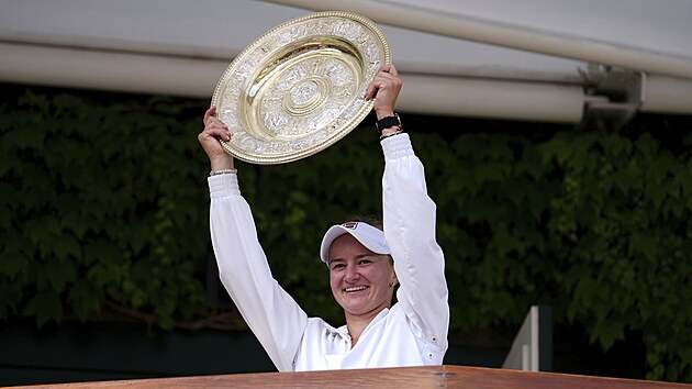 Barbora Krej�íková ukazuje divák�m wimbledonskou trofej.