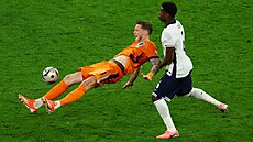 Nizozemec Wout Weghorst padá po souboji s Marcem Guéhim z Anglie.