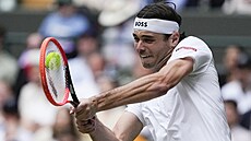 Taylor Fritz hraje bekhend ve tvrtfinálovém zápase Wimbledonu.
