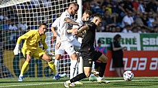 Mat�j Jurásek ze Slavie si kryje mí� p�ed hrá�i Slovácka.